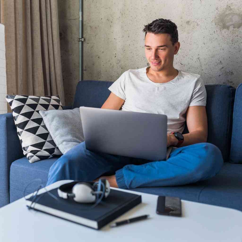 Attractive young man on couch with laptop
